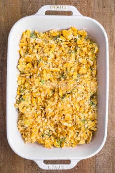 unbaked topped broccoli cheese casserole in a white baking pan.