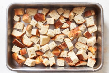 pieces of bread arranged at the bottom of a casserole dish