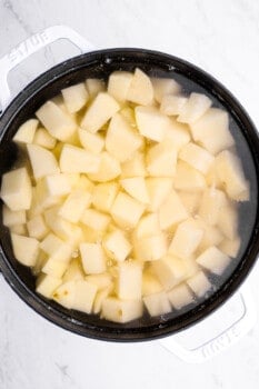 mashed potato cubes boiling in a stock pot.