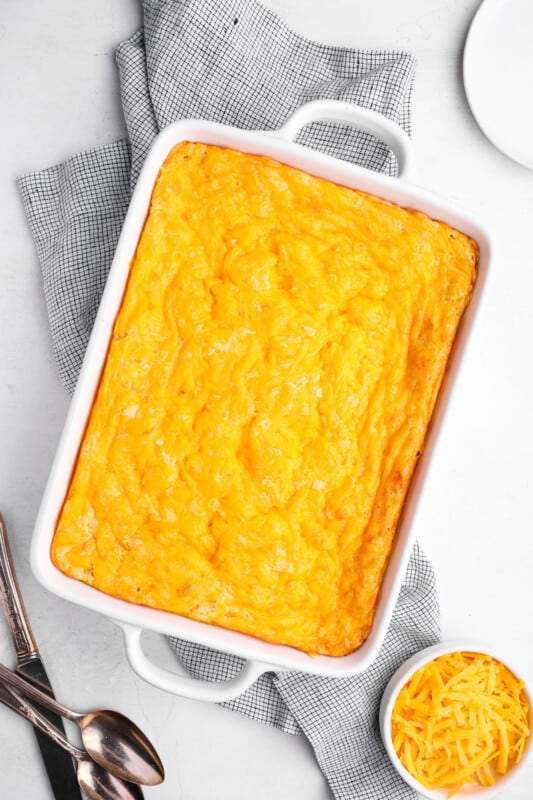 baked corn casserole in a white baking pan.