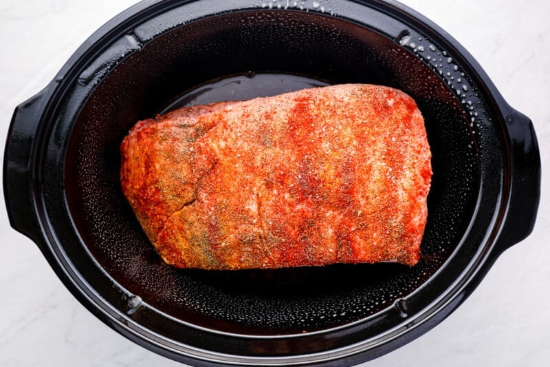 seasoned brisket placed in the crock pot