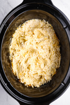 uncooked crockpot cheesy hashbrown potatoes in a crockpot.