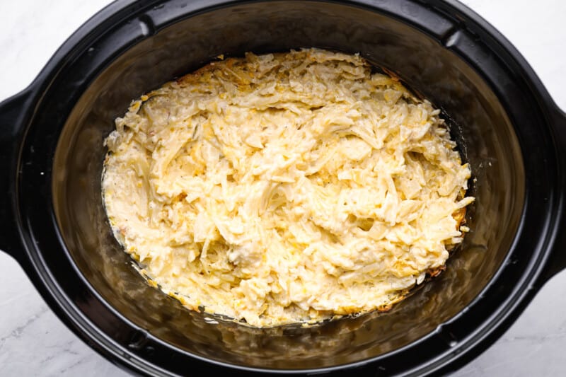 uncooked crockpot cheesy hashbrown potatoes in a crockpot.