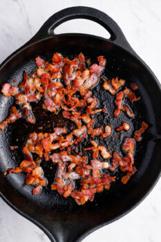 cooked diced bacon in a cast iron skillet.