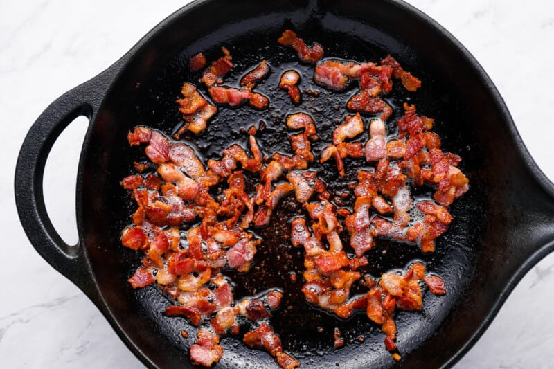 cooked diced bacon in a cast iron skillet.