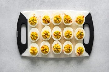 deviled eggs lined up on a cutting board