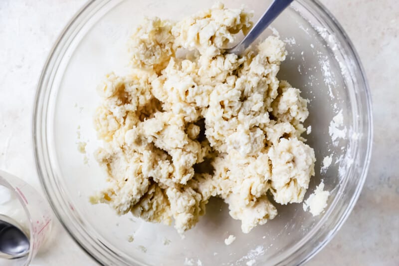 pie dough coming together in a mixing bowl