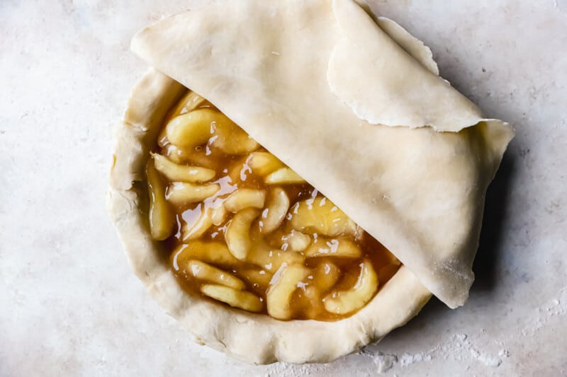 laying top crust on top of an apple pie