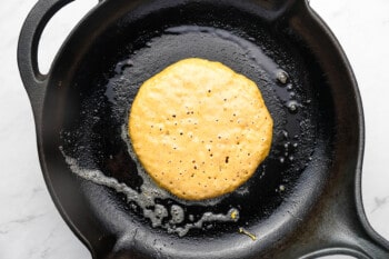 pancake batter bubbling as it cooks in a skillet