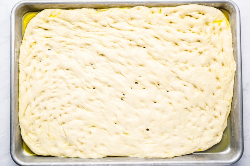 a square of dough in a pan on a white surface.