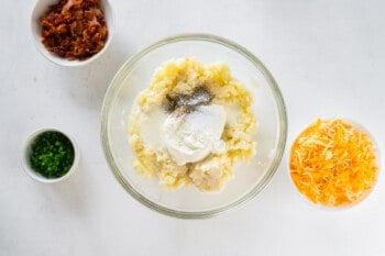 mashed potatoes, cream, and seasoning in a mixing bowl, before combining