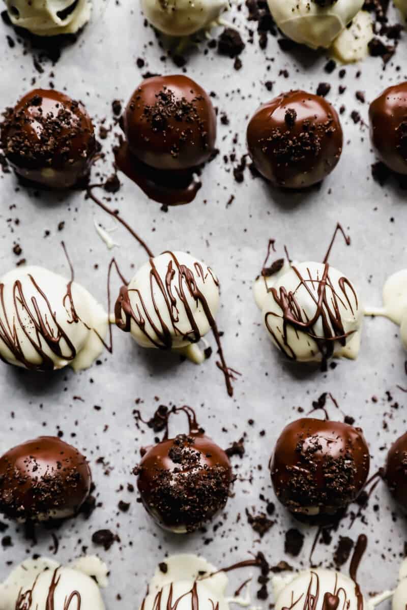 close up of oreo balls on a parchment lined baking sheet.