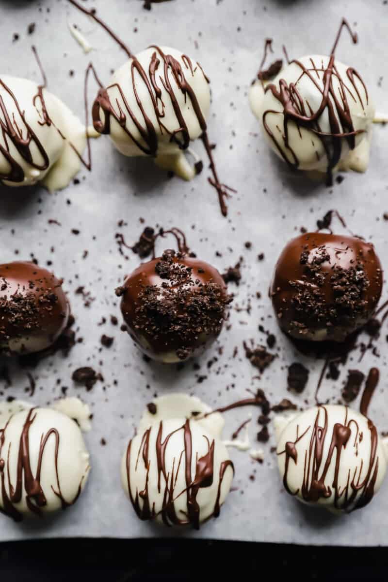 close up of oreo balls on a parchment lined baking sheet.