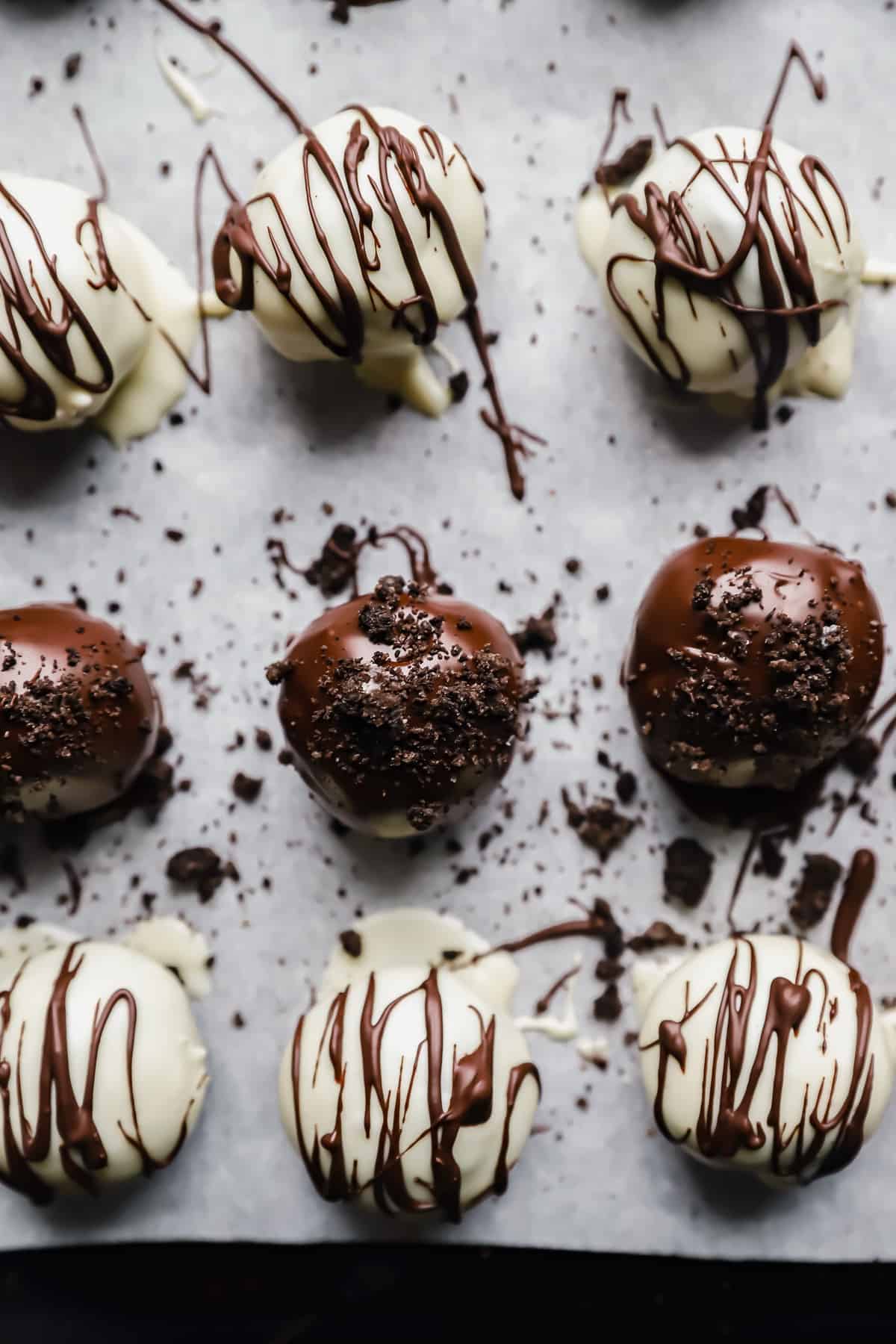 close up of oreo balls on a parchment lined baking sheet.