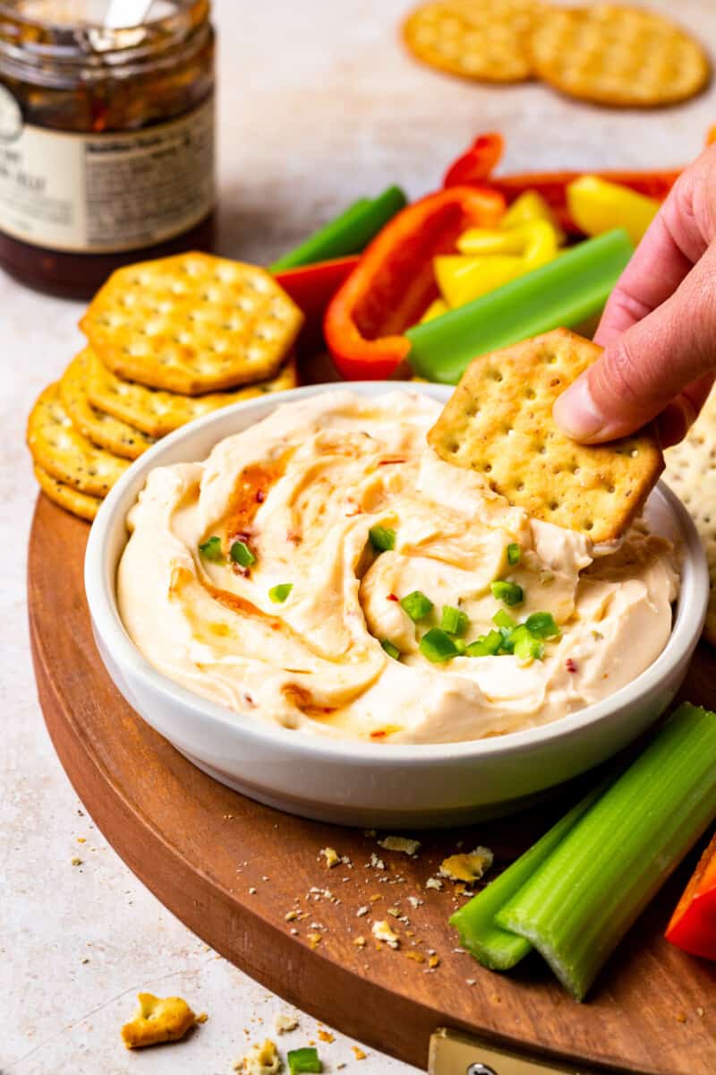 dipping a cracker into pepper jelly dip