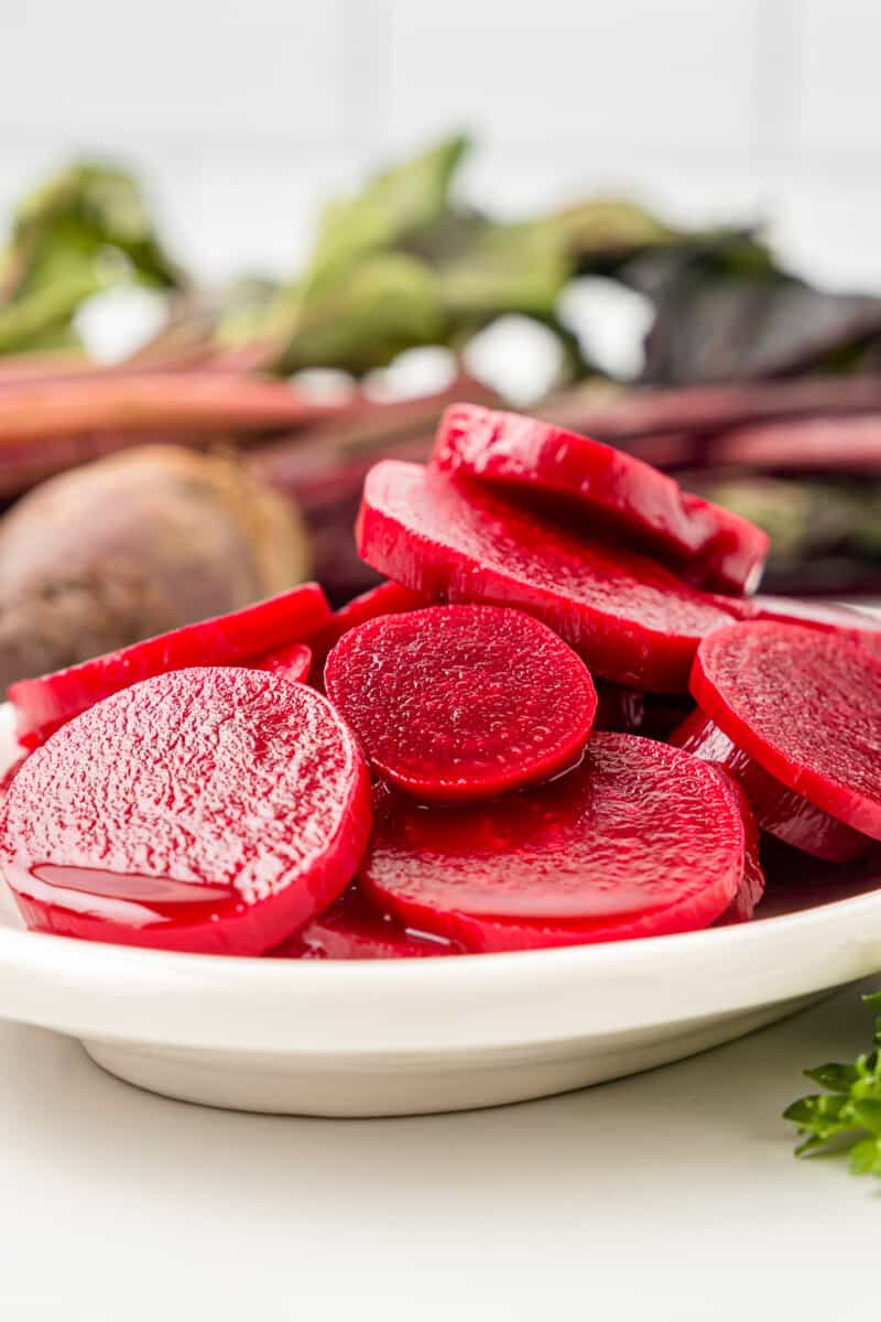side view of pickled beets on a white serving tray.