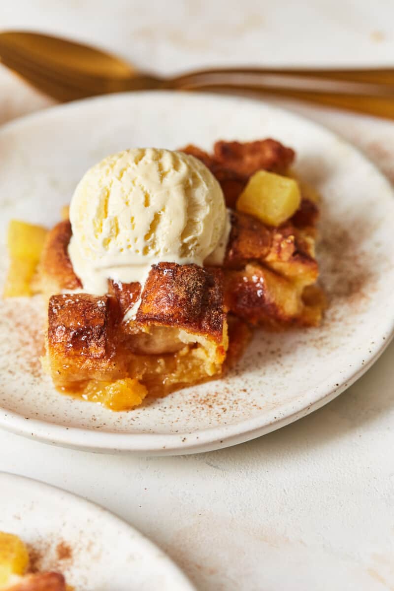 a plate of pineapple bread pudding with a scoop of vanilla ice cream