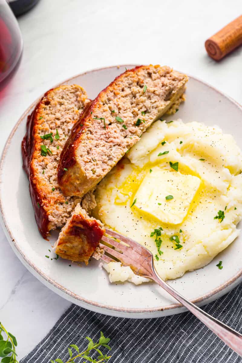 slice of turkey meatloaf and mashed potatoes on a dinner plate