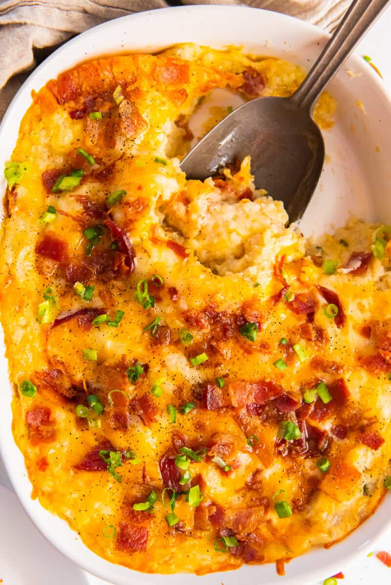 loaded baked potato casserole with a large serving spoon