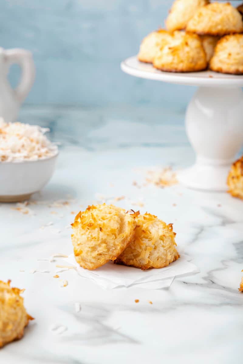 close up of a coconut macaroon leaning against another coconut macaroon.