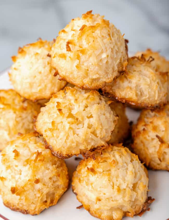 a pile of coconut macaroons on a white plate.