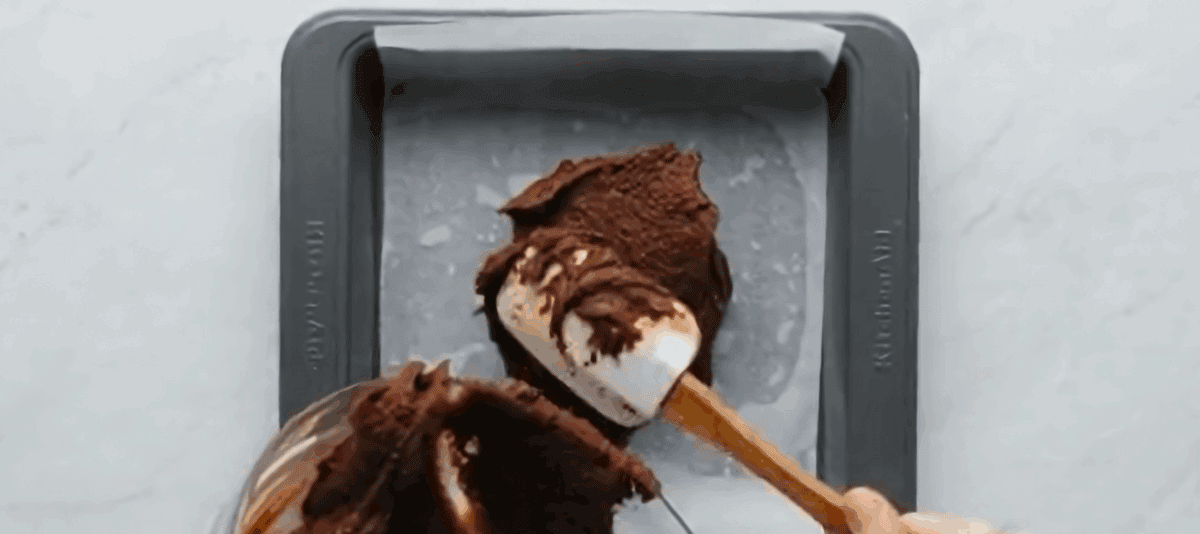 Pouring the brownie batter into the pan.