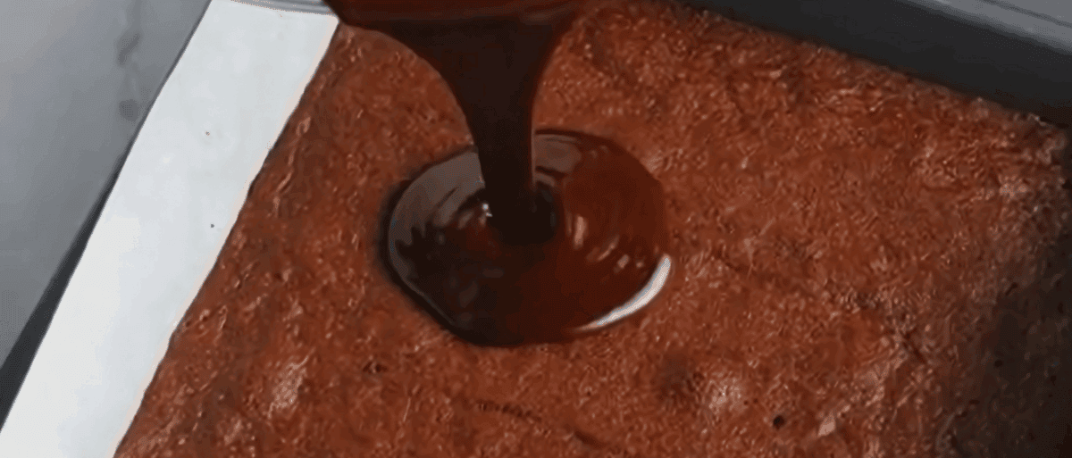 Pouring the frosting over the brownies. 