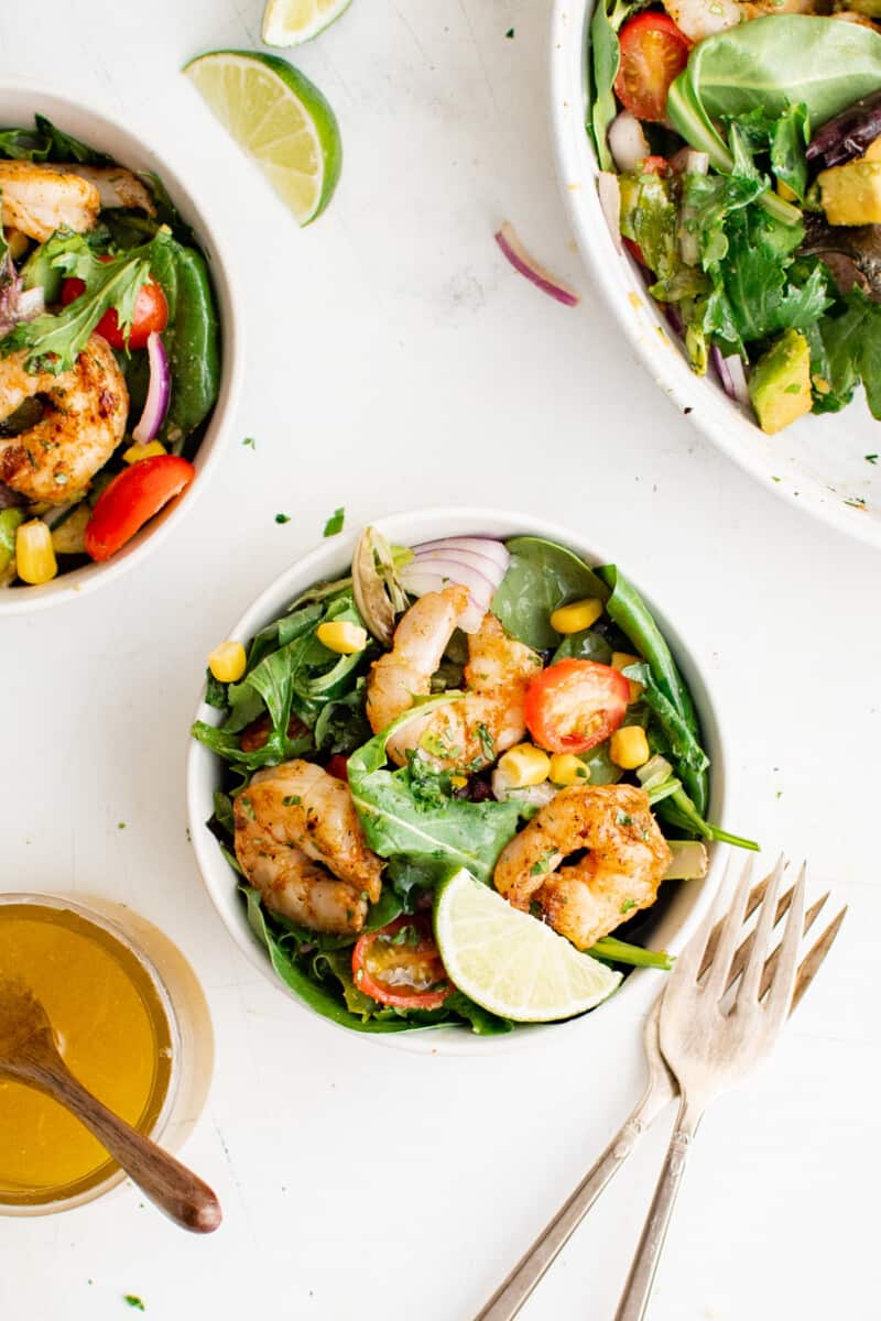 bowls of shrimp salad on a table with forks