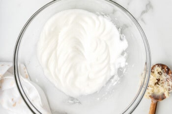 whipped egg whites in a glass bowl.