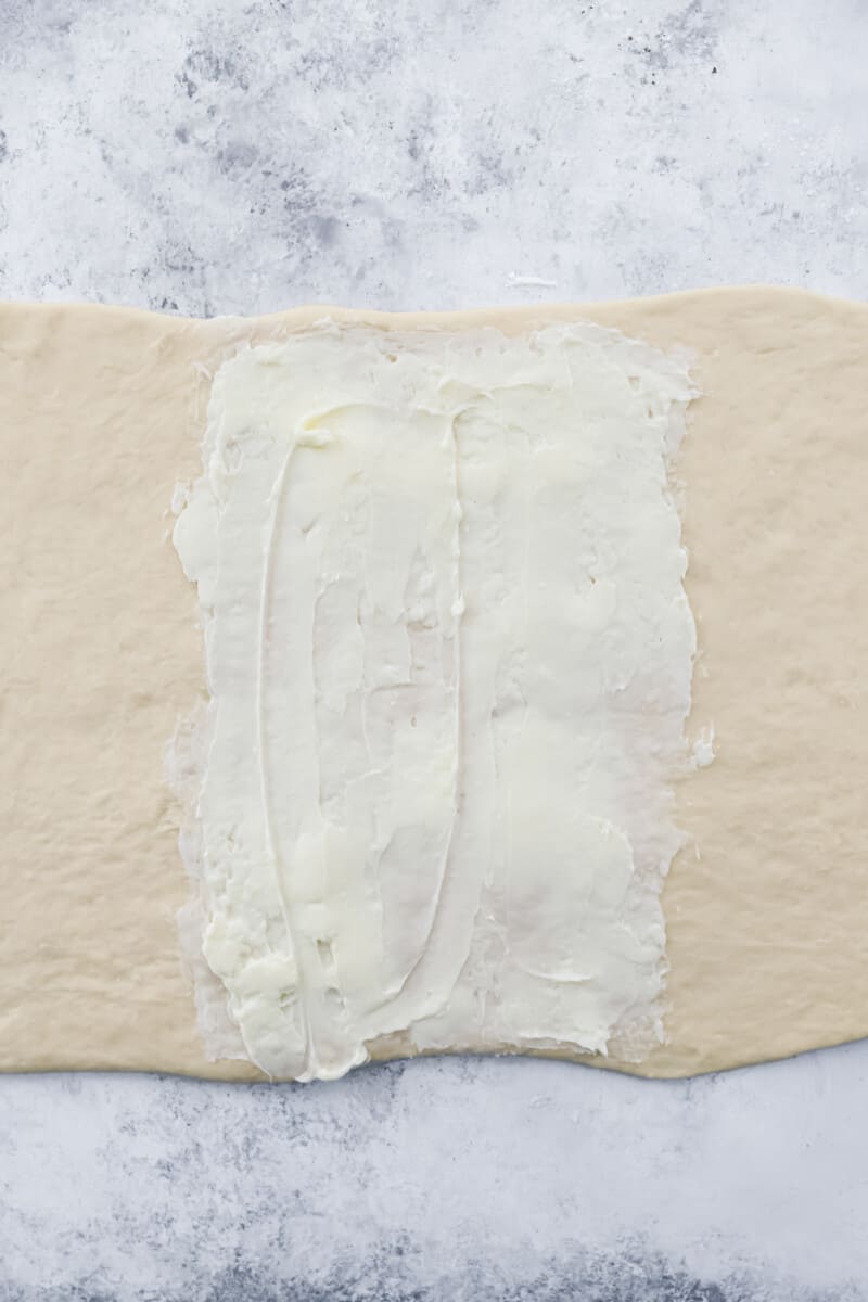 Buttered cronut dough on a marble counter.