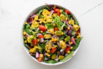 bowl of salad with brightly-colored veggies mixed in