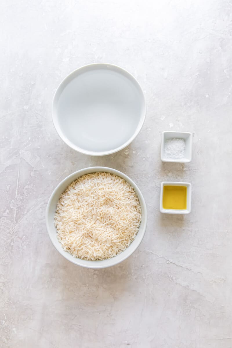 Overhead view of ingredients for instant pot basmati rice in individual white bowls.
