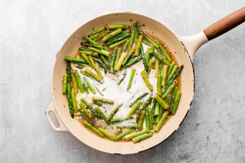 asparagus an creamy sauce in a skillet