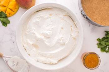 mango cheesecake filling in a white bowl.