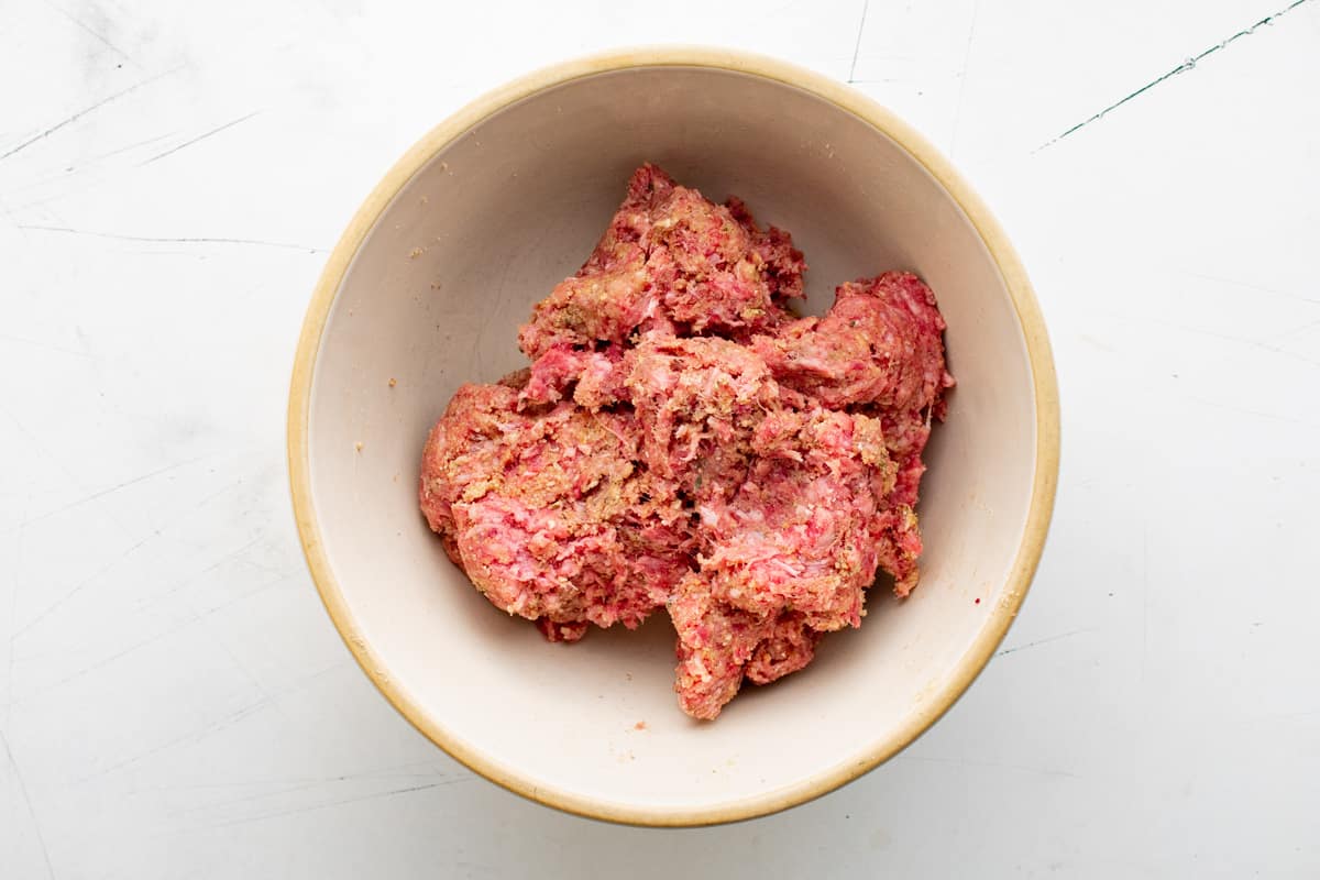 meatball mixture for meatball casserole in a white bowl.