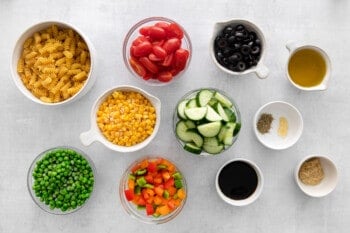 overhead view of ingredients for veggie pasta salad in individual bowls.