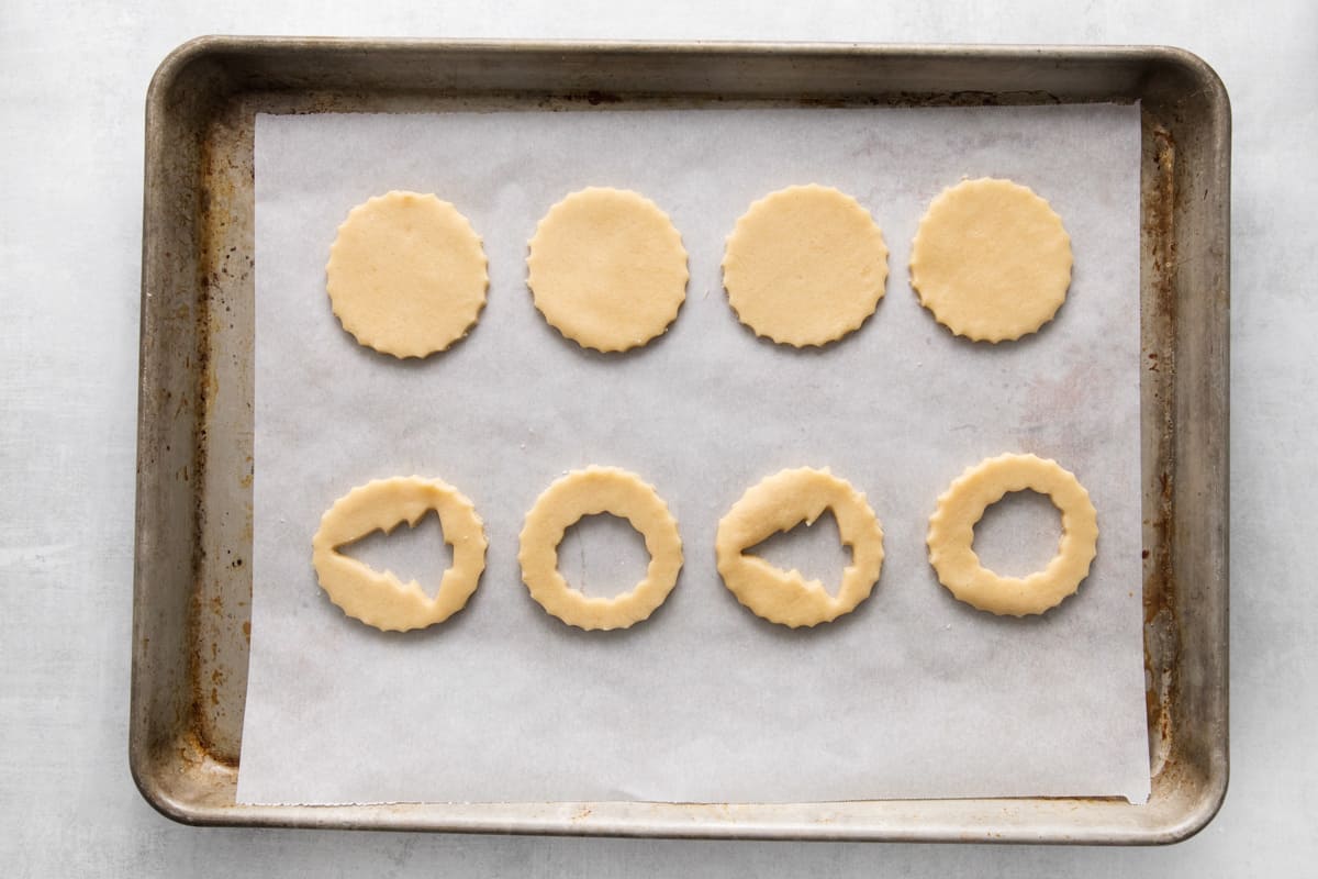 Linzer cookies lined up on a baking sheet.
