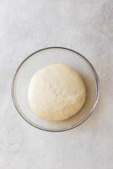 risen olive garden breadstick dough in a glass bowl.