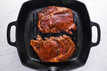 2 ribeyes in a cast iron grill pan.