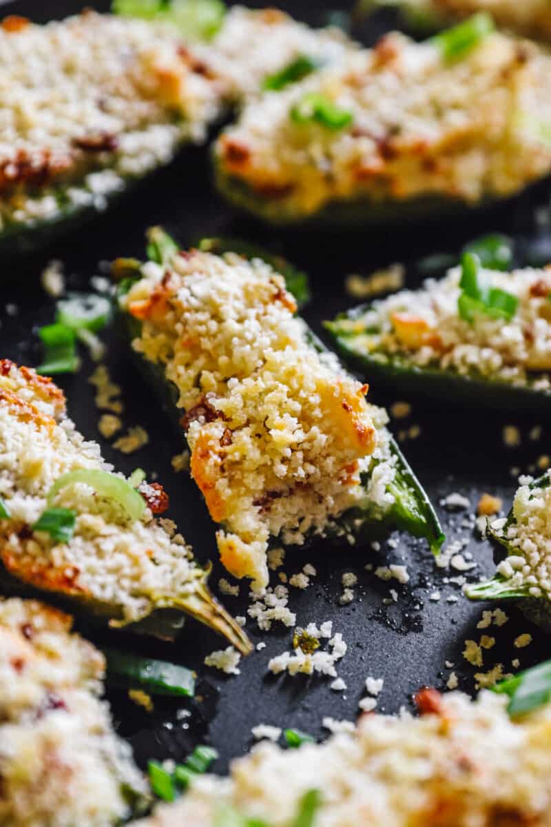 close up on jalapeño poppers, one with a bite taken out