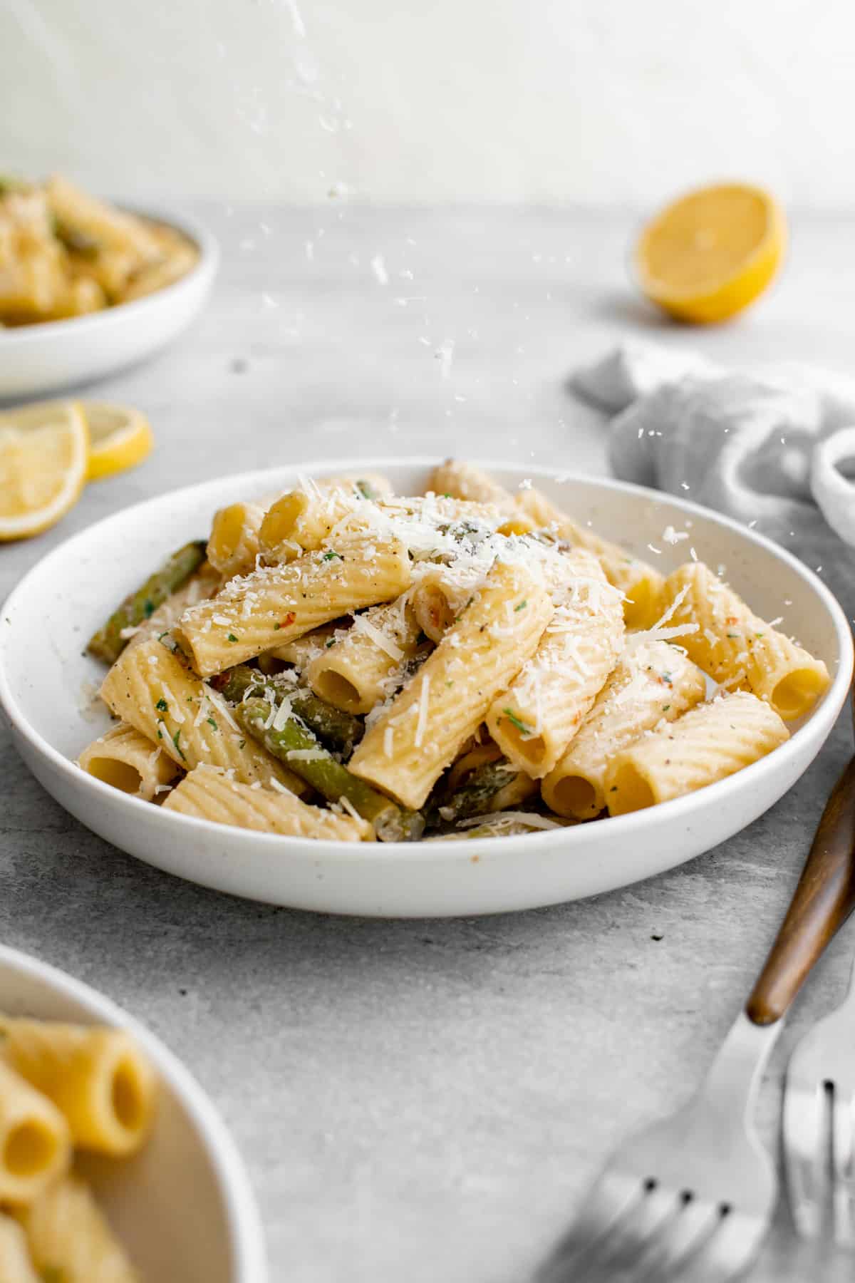 Shallow bowl full of pasta with asparagus. - 9