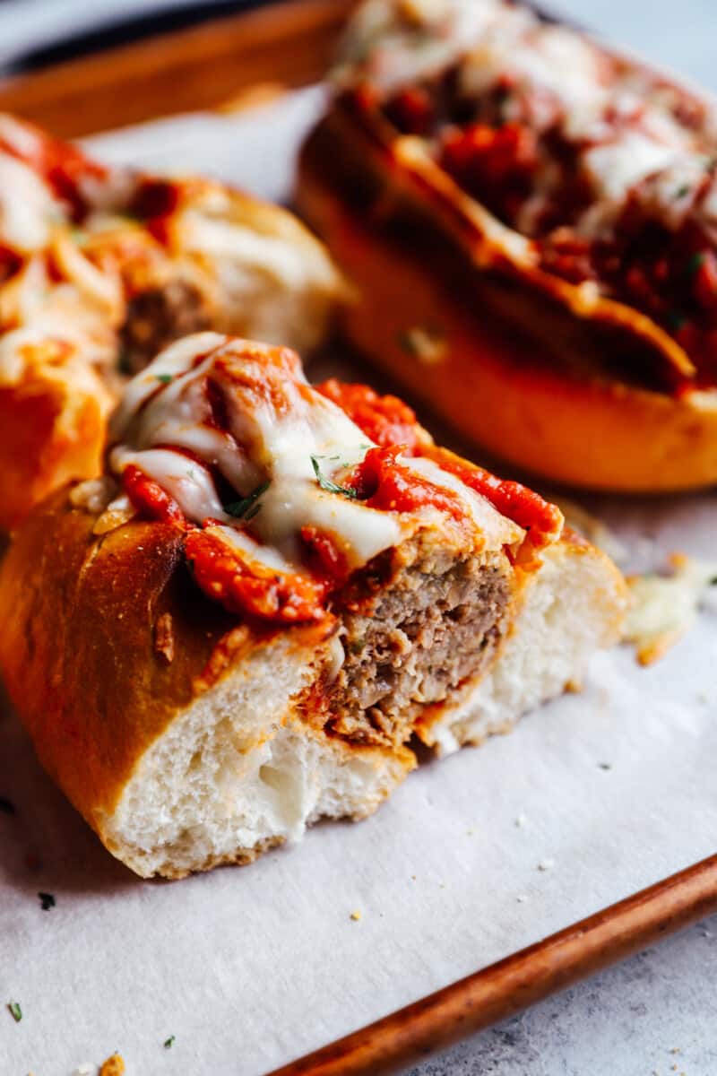 cross section of a meatball sub on a lined baking sheet.