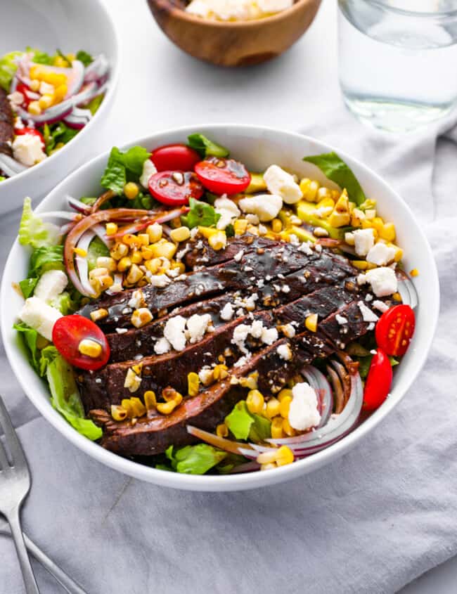 steak salad in a white bowl.