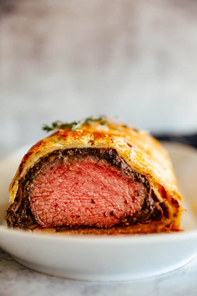 beef Wellington sliced and on a white plate