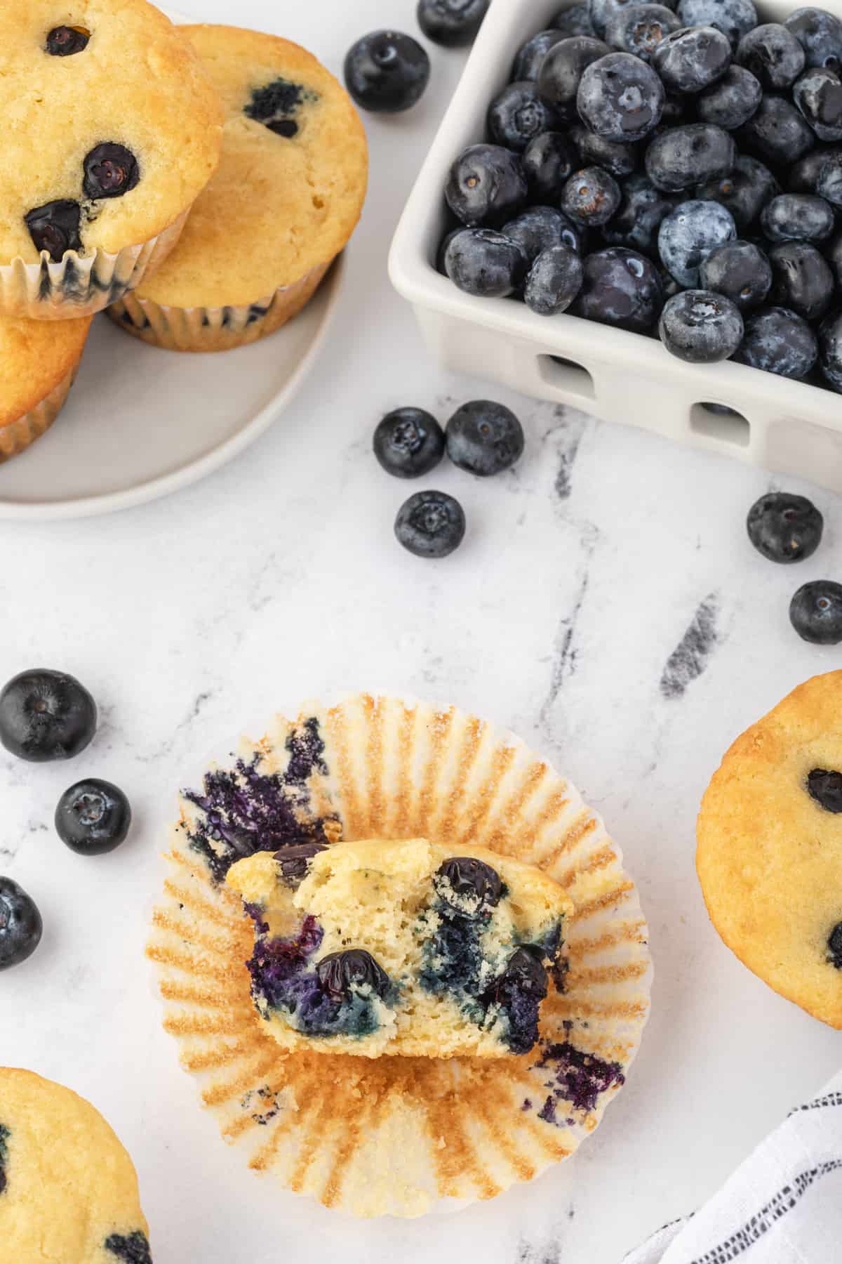 a halved unwrapped blueberry pancake muffin resting on a muffin liner.