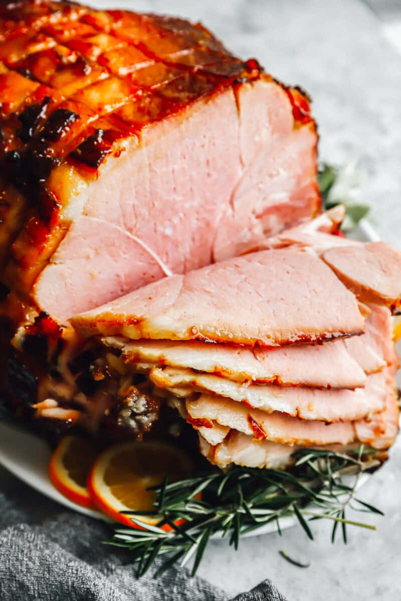 sliced brown sugar glazed ham on a platter.