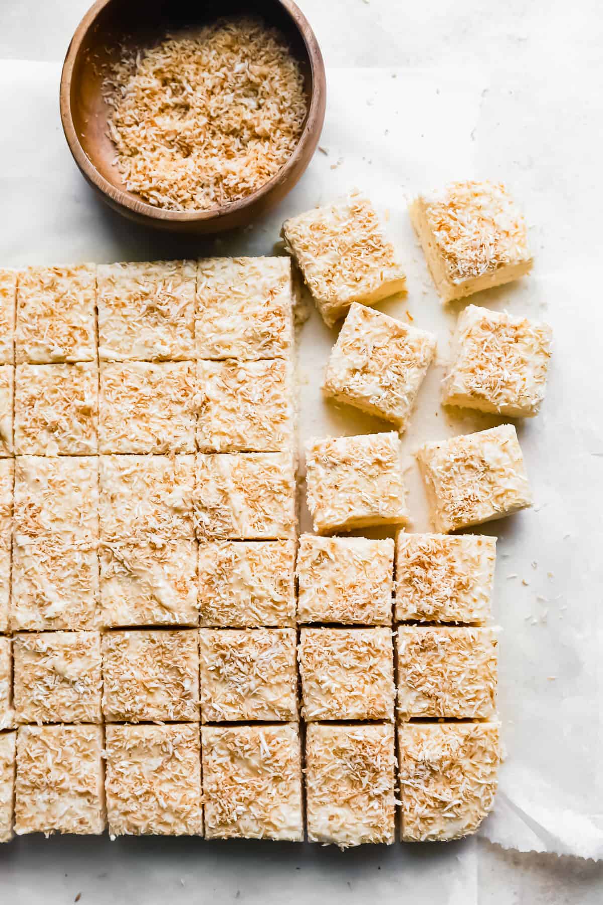 cut coconut fudge on a white table.