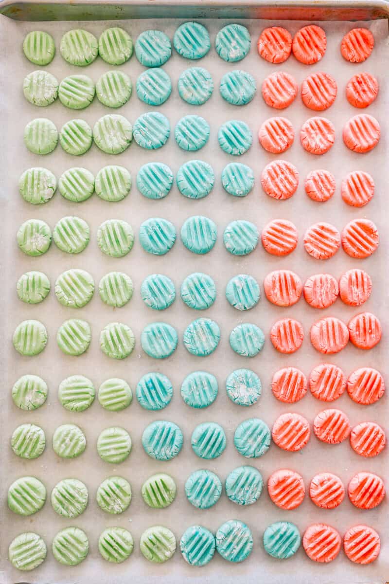 about 100 cream cheese mints on a baking sheet.