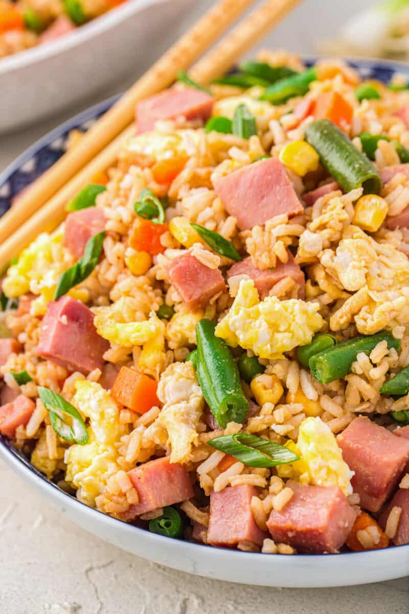 ham fried rice in a white bowl with chopsticks.