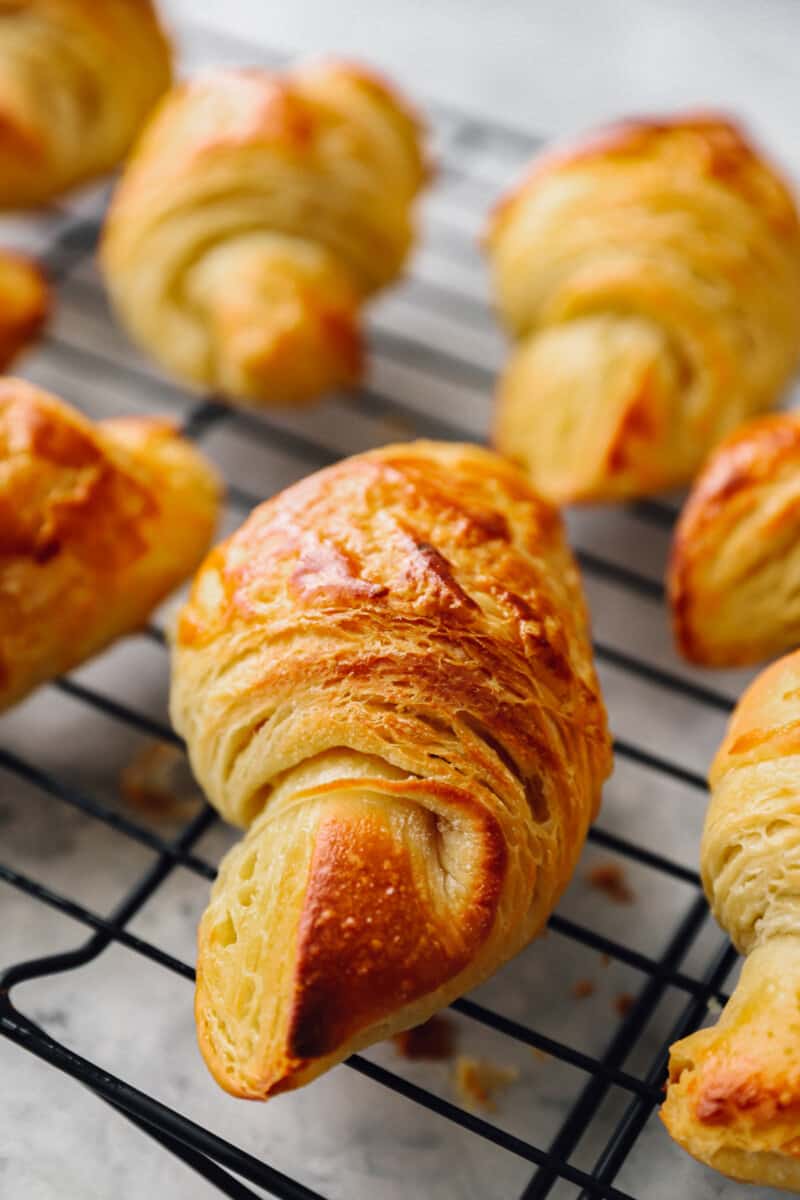 close up view of croissants on a wire rack.